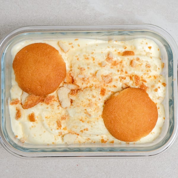 Sweet Valentine Bakery's banana pudding with vanilla wafers and crumbs in a glass dish.