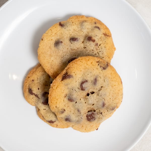 Three Sweet Valentine Bakery chocolate chip cookies on a white plate.